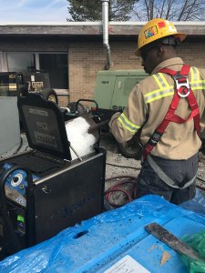Crew member loading dry ice into blasting equipment before job